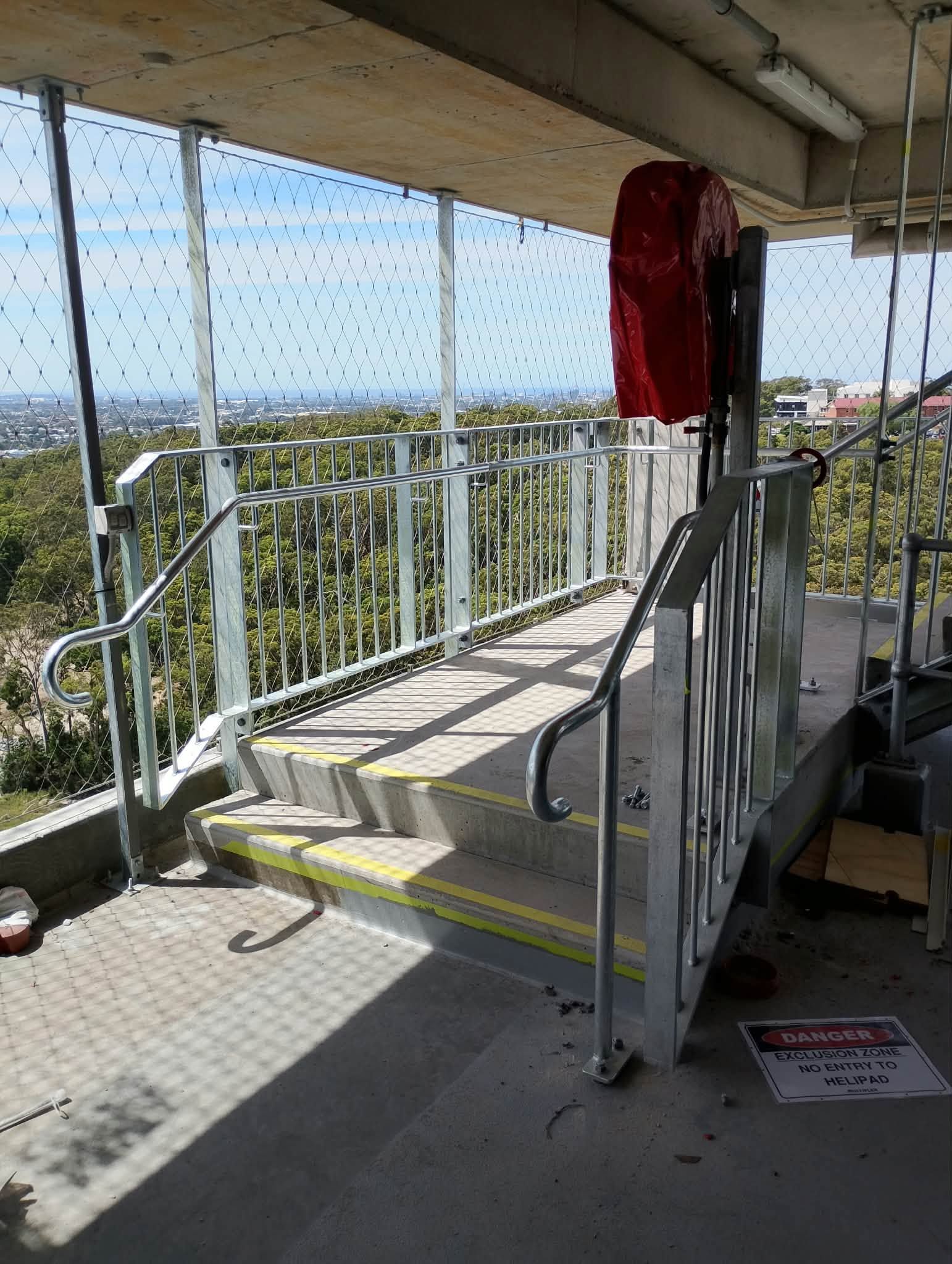 Galvanised steel handrails and balustrade around steps on an upper level overlooking bushland